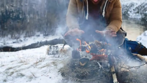 Man heating on bonfire in winter Miniatura di YouTube template