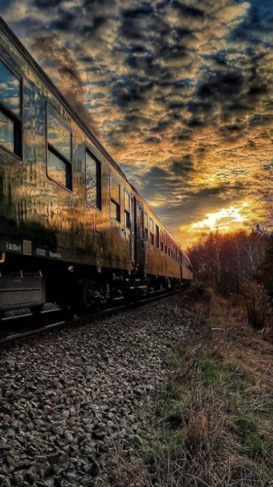 Passenger Train Traveling On Railway Track At Dramatic Sunset Sky ...